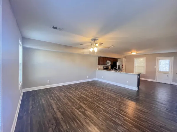 a view of a kitchen with cabinets and wooden floor