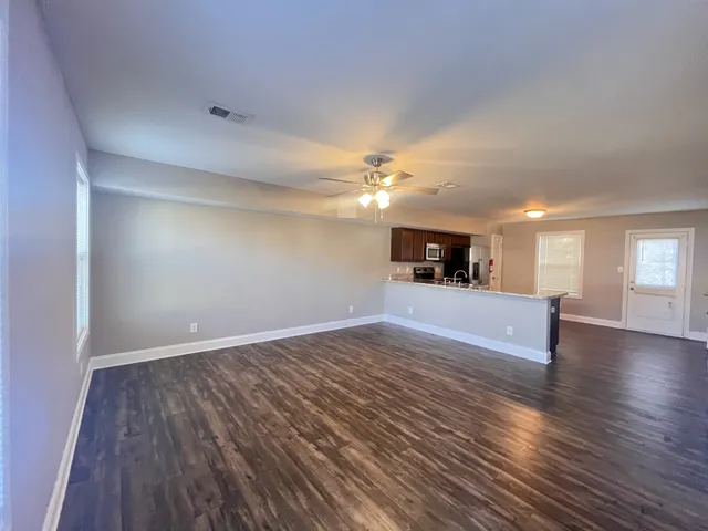 a view of a kitchen with cabinets and wooden floor