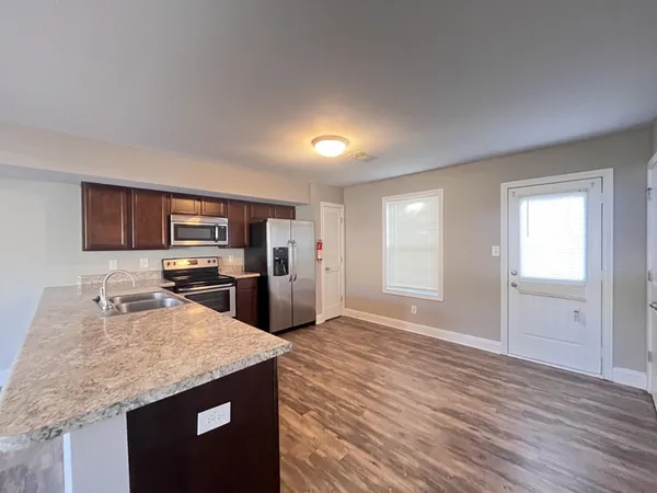 a kitchen with stainless steel appliances granite countertop a sink stove and refrigerator