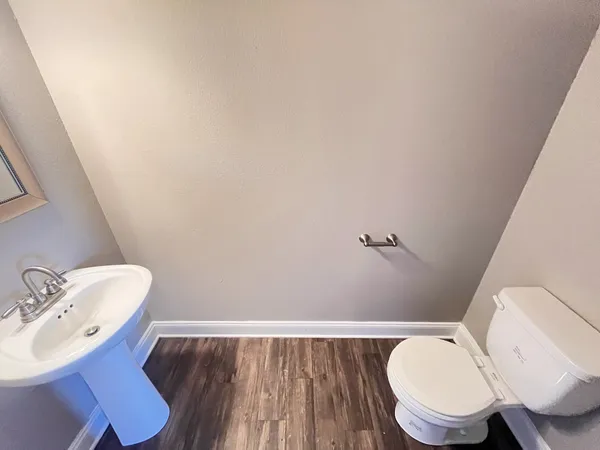 a bathroom with a toilet a sink and mirror