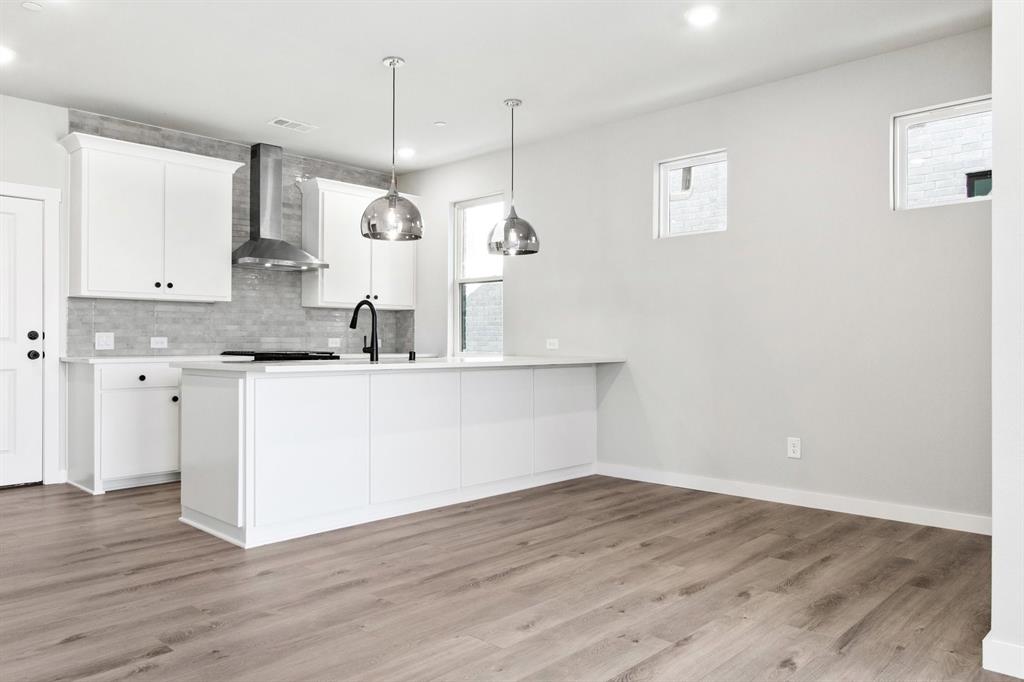 2020 Aldrich Road Celina, TX 75009 - Photo 11 of 40 a room with kitchen island white cabinets and wooden floor