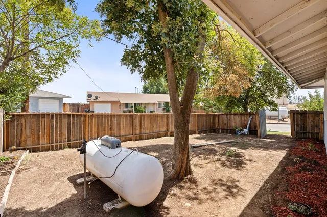 a view of a backyard with furniture and tree