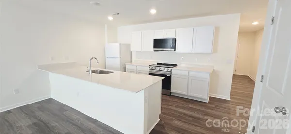 a kitchen with a sink a stove and a microwave