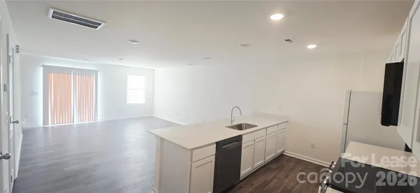 a view of a kitchen with a sink and wooden floor