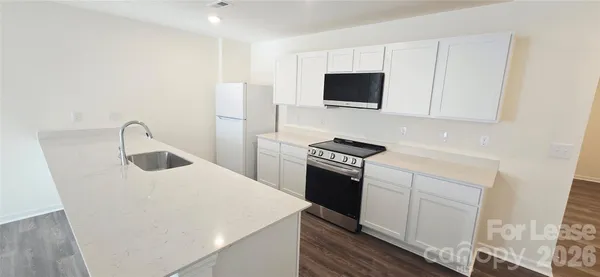 a kitchen with stainless steel appliances a microwave a sink and a stove