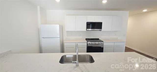 a kitchen with a sink stove and refrigerator