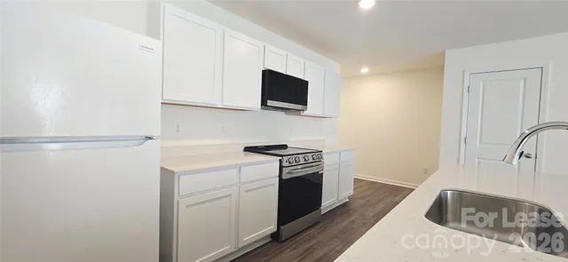 a kitchen with granite countertop cabinets stainless steel appliances and wooden floor