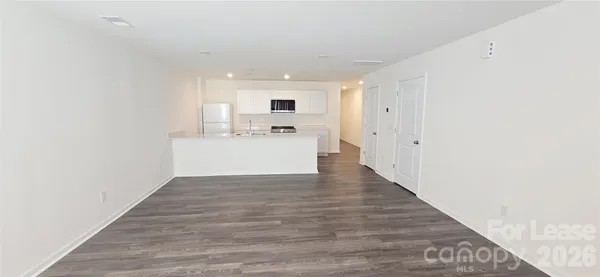 a view of a kitchen with wooden floor and electronic appliances