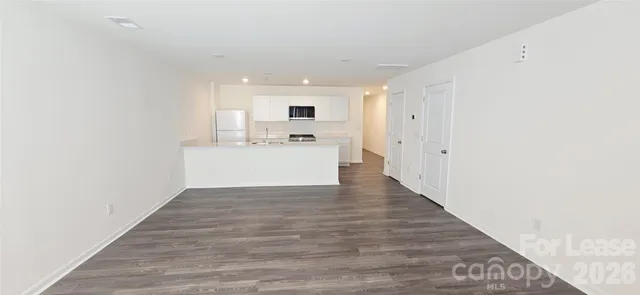 a view of a kitchen with wooden floor and electronic appliances