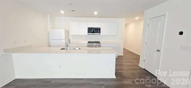 a room with a sink a mirror and wooden floor
