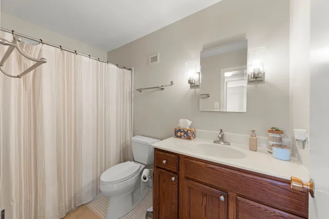 a bathroom with a sink a toilet and shower curtain