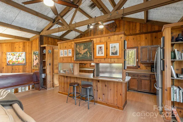 a kitchen with stainless steel appliances granite countertop a table chairs and wooden floors
