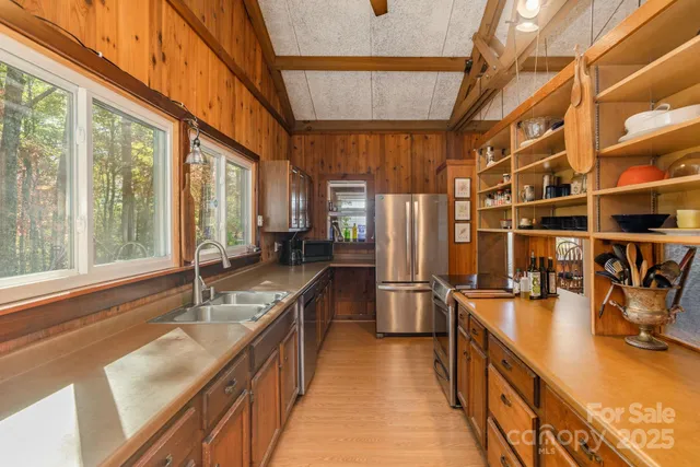 a kitchen with stainless steel appliances granite countertop a sink and wooden cabinets