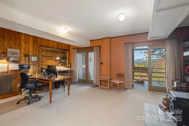 a view of a livingroom with workspace and a window