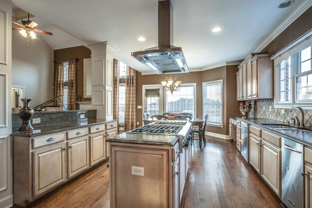 438 Beauchamp Circle Franklin, TN 37067 - Photo 11 of 30 a kitchen with stainless steel appliances granite countertop a stove top oven a sink dishwasher a dining table and chairs with wooden floor