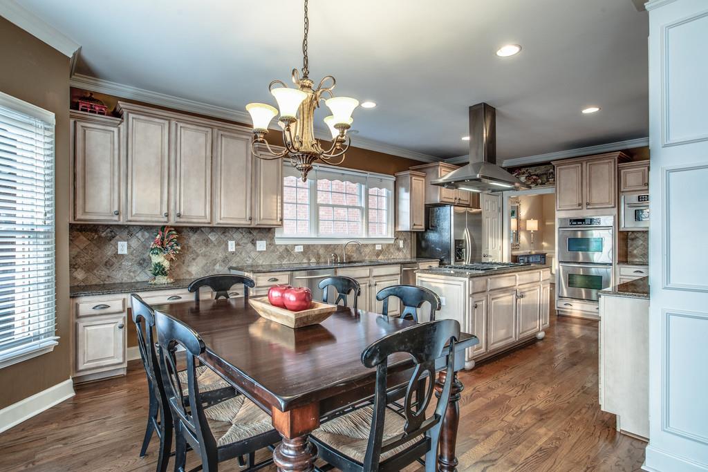 438 Beauchamp Circle Franklin, TN 37067 - Photo 9 of 30 a kitchen with stainless steel appliances granite countertop a sink a stove a refrigerator cabinets and chairs