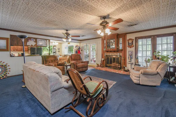 a living room with furniture a chandelier and a large window