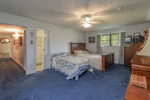 a bedroom with a large bed a chandelier and closet