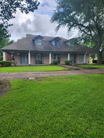 a front view of a house with a yard and trees