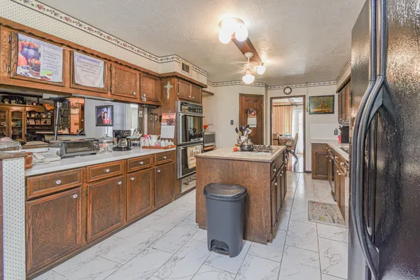 a kitchen with stainless steel appliances granite countertop a sink a stove and a refrigerator