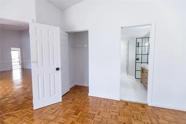 a view of a hallway with wooden floor and entryway