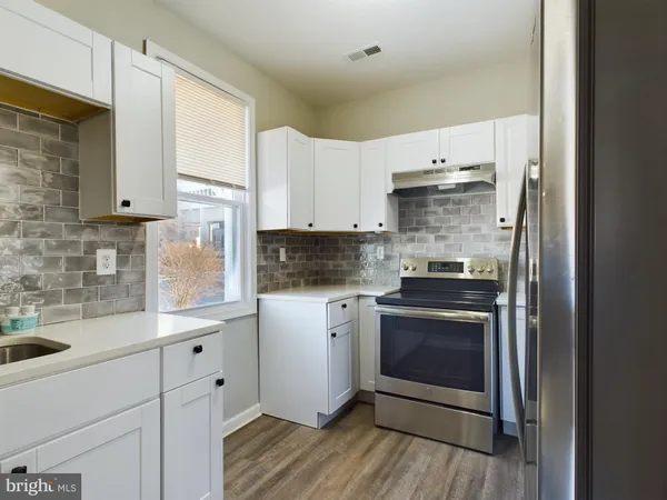 a kitchen with stainless steel appliances white cabinets and a sink