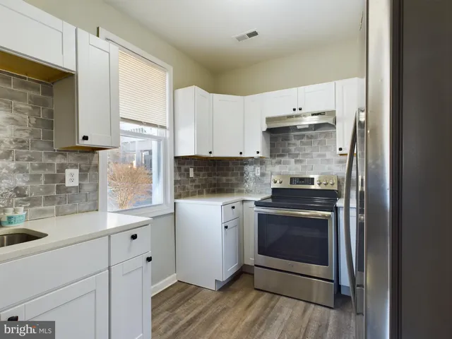 a kitchen with stainless steel appliances white cabinets and a sink