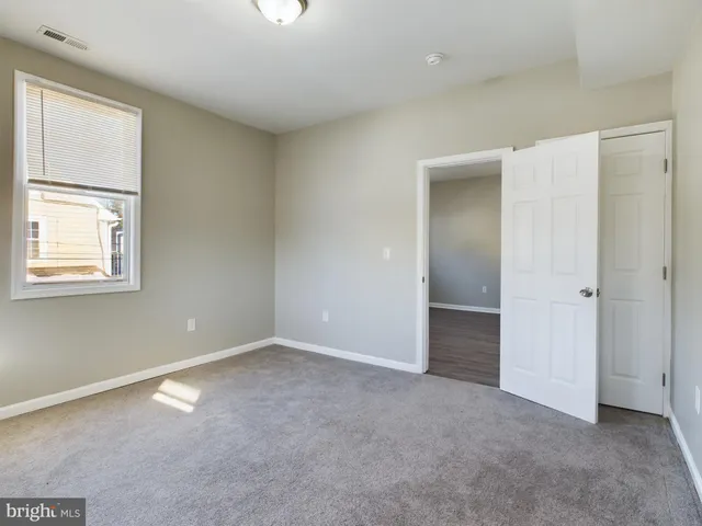 an empty room with windows and closet