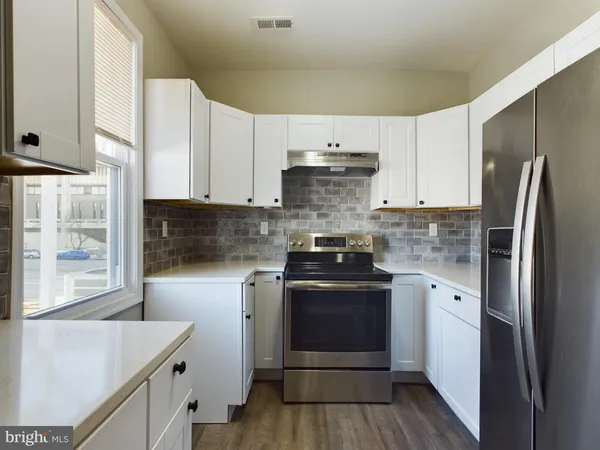 a kitchen with a stove sink and refrigerator
