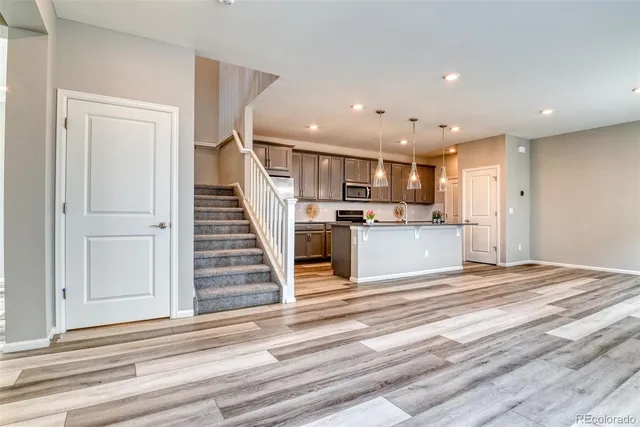 a view of a kitchen with wooden floor and electronic appliances