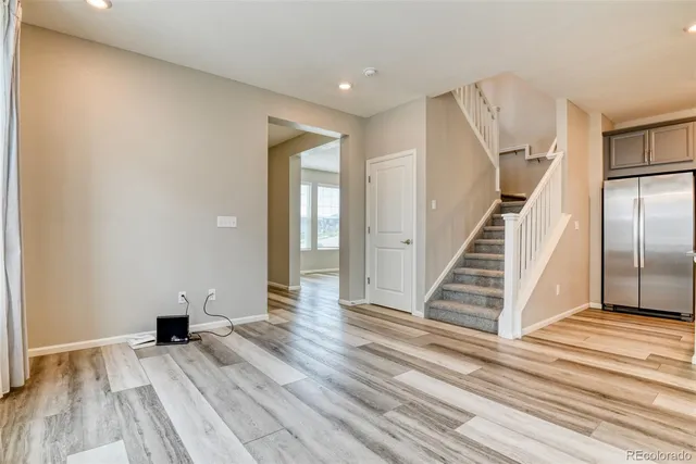a view of a livingroom with wooden floor and stairs