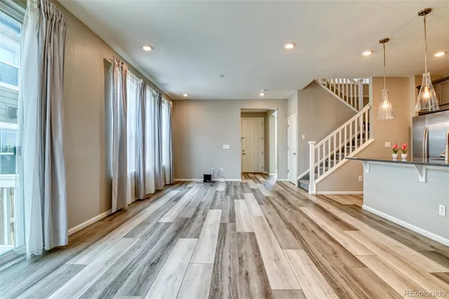 a view of a livingroom with wooden floor and stairs