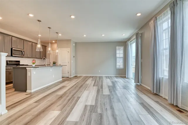 a view of kitchen with wooden floor and electronic appliances
