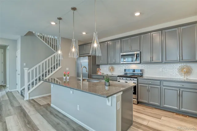 a kitchen with a sink a stove a refrigerator and cabinets