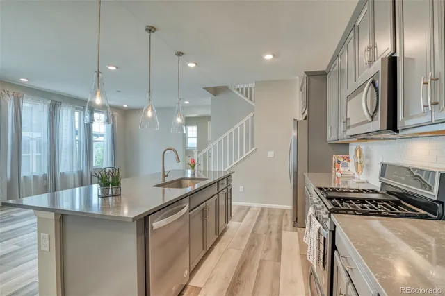 a kitchen with stainless steel appliances granite countertop a sink stove and refrigerator