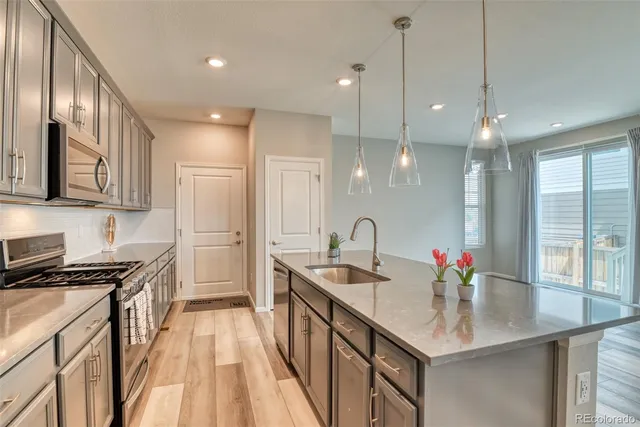 a kitchen with stainless steel appliances granite countertop a sink stove and cabinets