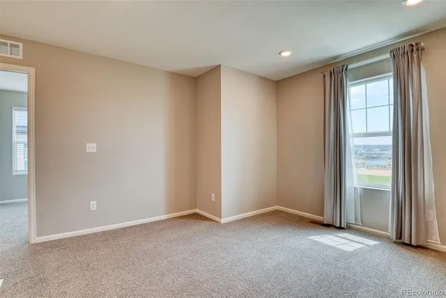 an empty room with windows and closet
