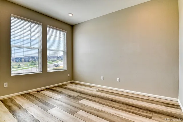a view of a bedroom with wooden floor and a window