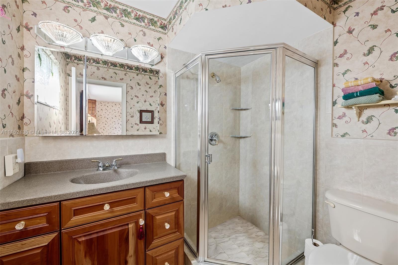 4314 Fillmore Street Hollywood, FL 33021 - Photo 18 of 27 a bathroom with a granite countertop shower sink vanity and mirror