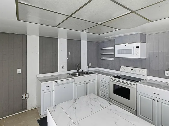 a kitchen with white cabinets and white appliances
