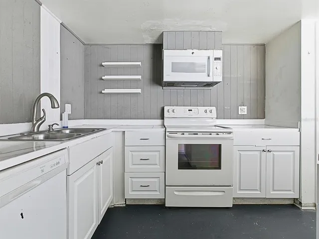 a kitchen with white cabinets and white appliances