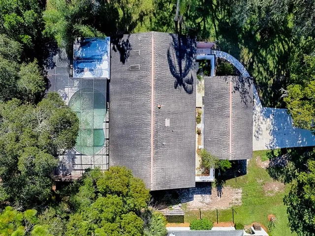 an aerial view of house that has swimming pool