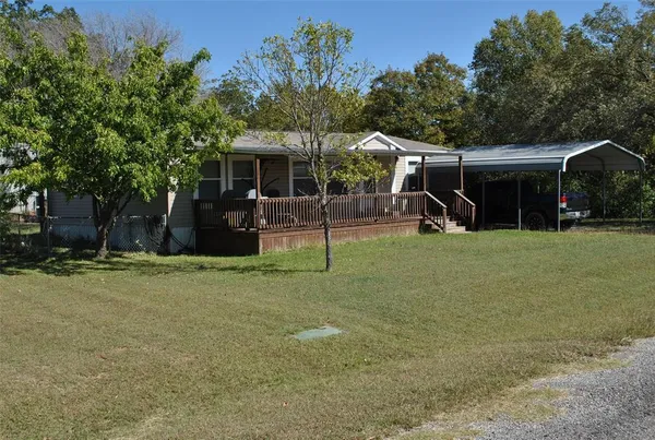 a view of a house with backyard and a tree