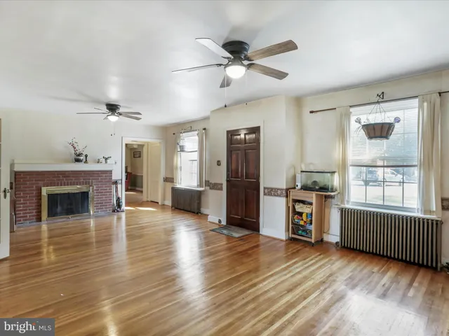 a view of a livingroom with furniture a ceiling fan and wooden floor