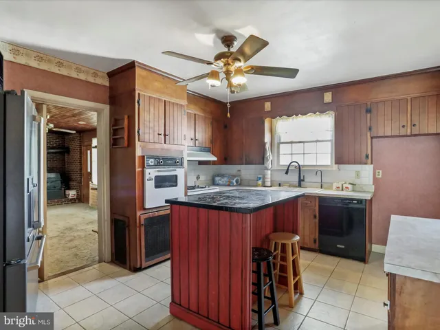 a kitchen with kitchen island granite countertop a sink counter top space appliances and cabinets