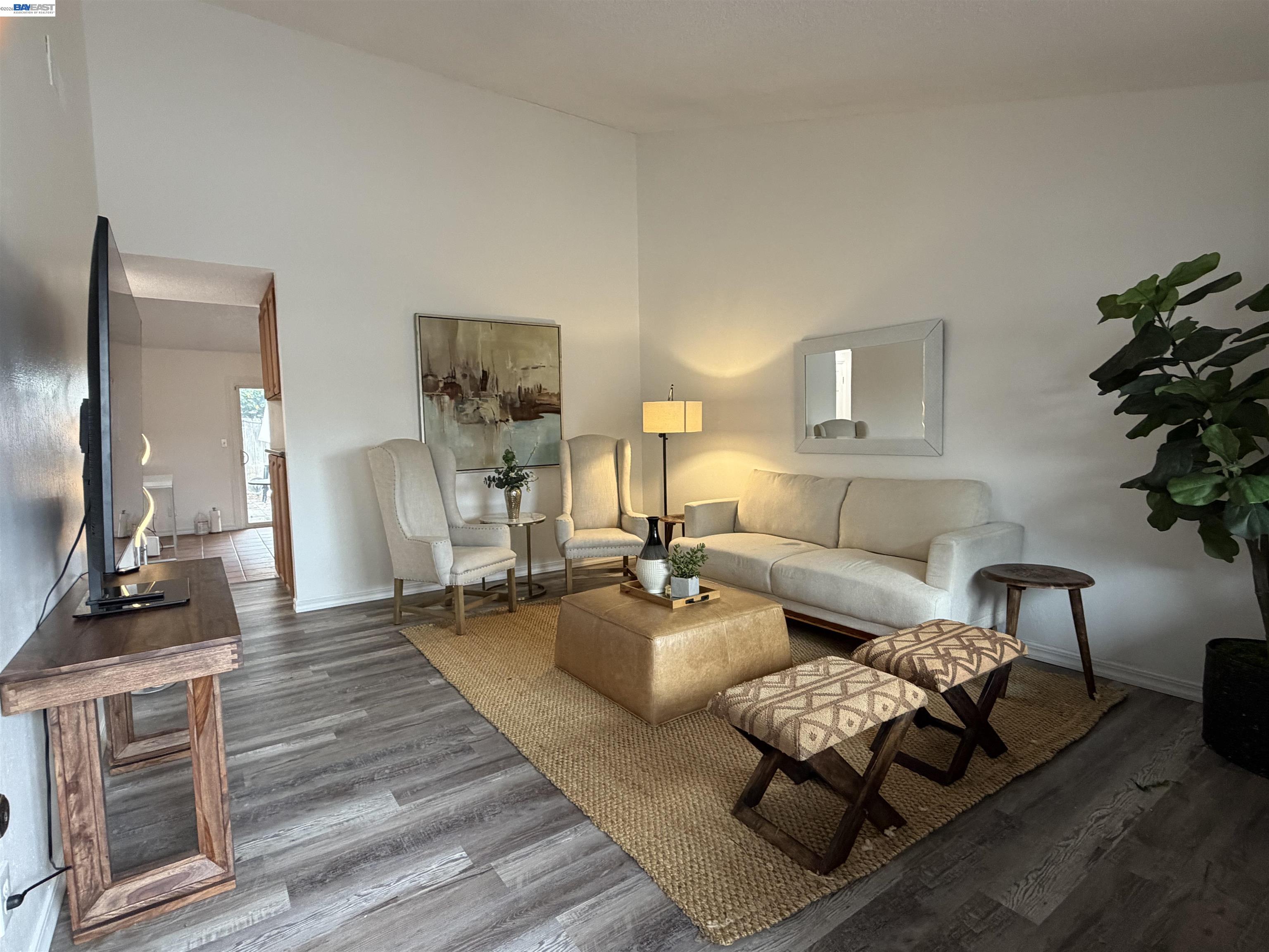 a living room with furniture and a wooden floor