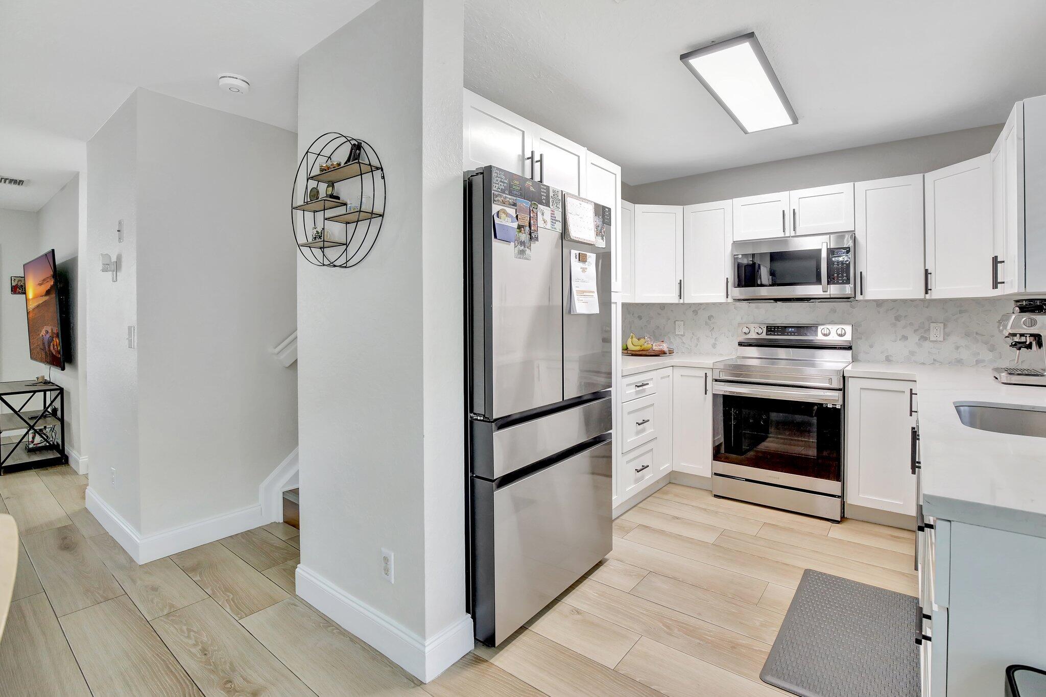 8730 Southwest 21st Street Miramar, FL 33025 - Photo 12 of 45 a kitchen with a refrigerator and a stove top oven