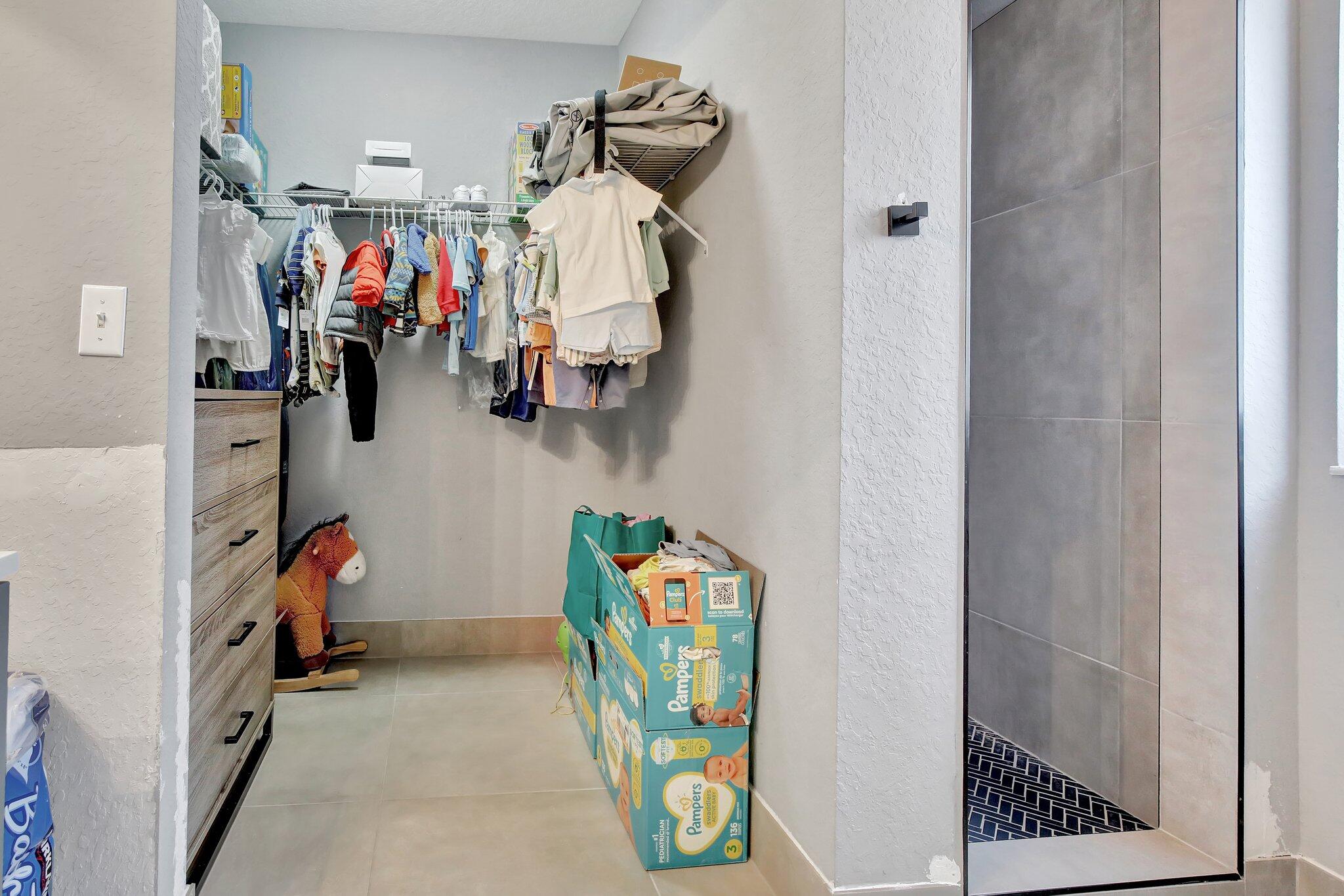 8730 Southwest 21st Street Miramar, FL 33025 - Photo 19 of 45 a view of walk in closet with clothes and shoes