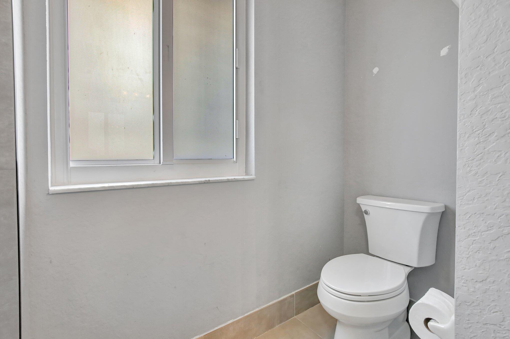 8730 Southwest 21st Street Miramar, FL 33025 - Photo 20 of 45 a white toilet sitting next to a bathroom sink