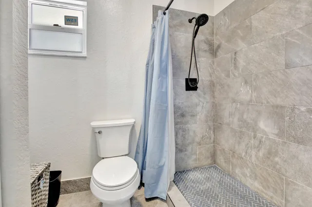 a bathroom with a toilet and a shower